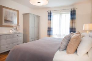 a bedroom with a bed with pillows and a dresser at Modern & central - two bedroom & two bathroom apartment in Bath