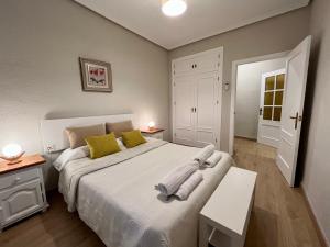 a bedroom with a large white bed with yellow pillows at Apartamento Castilla 30 - Parking Publico Gratuito in Toledo