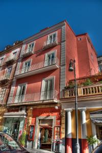 un edificio rojo en una calle de la ciudad con luz de la calle en New Domus Sorrento, en Sorrento
