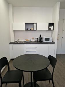 a kitchen with a table and chairs and a microwave at Casa Antelami in Salsomaggiore Terme