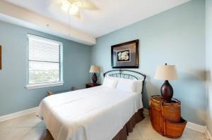 a bedroom with a large bed with blue walls at Grand Pointe Unit 414 in Orange Beach +27 photos
