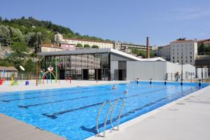 una gran piscina con gente jugando en ella en Suite 3 pièces chambre+cuisine+SDB centre ville, en Privas