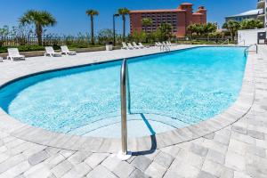 a large swimming pool with chairs and a building at Grand Pointe Unit 414 in Orange Beach