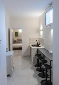 a kitchen with a sink and some black stools at Oronti Accommodations in Lecce