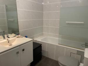 a bathroom with a tub and a sink and a toilet at Nuit Étoilée in Aubervilliers