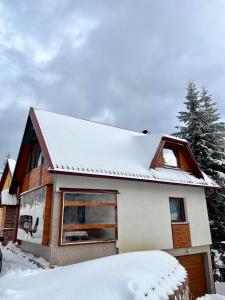 una casa cubierta de nieve con garaje en Sara Apartments Pridolci, en Kozica