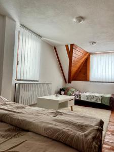 1 dormitorio con 2 camas, mesa y ventanas en Sara Apartments Pridolci, en Kozica