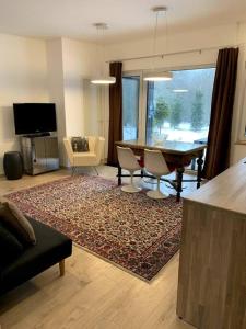 ein Wohnzimmer mit einem Tisch und Stühlen sowie ein Esszimmer in der Unterkunft Small cozy 3-room house with terrace & large garden in Ilmandu