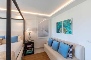 1 dormitorio con cama, sofá y espejo en Art et mer suite Saint barth, en Anse des Cayes