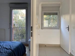 a bedroom with a bed and a door with a window at Nuit Étoilée in Aubervilliers