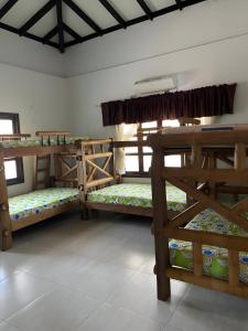 a room with three bunk beds in a room at El Hotel De La Tía in San Bernardo del Viento