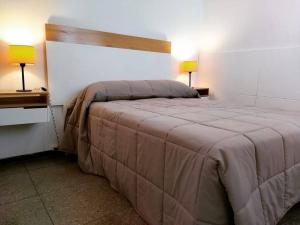 a bedroom with a large bed with two lamps on tables at Departamento amplio, cerca de todo in Guaymallen