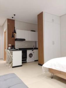 a white room with a kitchen with a microwave at Studio à Prestigia HayRiad/Rabat in Rabat