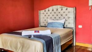 Cama en habitación con pared roja en Hotel LUCHINE, en Pucallpa