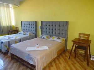 1 dormitorio con 2 camas y mesa en Hotel LUCHINE, en Pucallpa