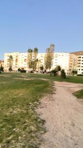 un chemin de terre dans un parc avec des bâtiments en arrière-plan dans l'établissement Tetouan Relax Apartement, à Tetouan