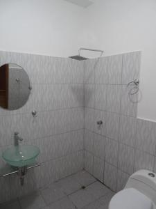 uma casa de banho com um lavatório, um espelho e um WC. em Hotel LUCHINE em Pucallpa
