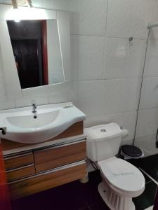 a bathroom with a sink and a toilet and a mirror at Aconchegante Apartamento em Ouro Preto in Ouro Preto