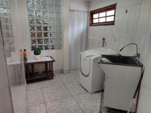 欧鲁普雷图Aconchegante Apartamento em Ouro Preto的配有洗衣机和水槽的浴室
