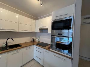 a kitchen with a stove top oven with a microwave at Bursztynowy Apartament in Jantar
