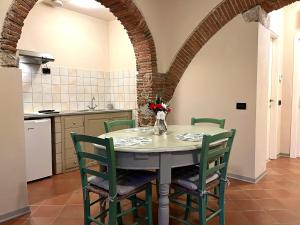 einen Tisch und Stühle in einer Küche mit einem Torbogen in der Unterkunft Agriturismo il Ghiaccio in Suvereto