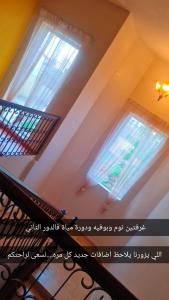a staircase with two windows in a room at شاليهات الدرب منتجع ليله in Qarār