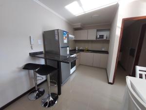 a kitchen with a refrigerator and two bar stools at VENETO VILLAGE MR in Villa Parque Siquiman +7 photos
