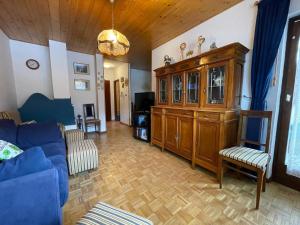 sala de estar con sofá azul y armario de madera en A Casa Dei - Appartamento Colle Isarco, en Colle Isarco