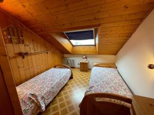 a small room with two beds in a cabin at A Casa Dei - Appartamento Colle Isarco in Colle Isarco