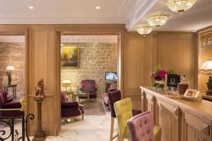 un salón con un bar con sillas moradas y amarillas en Académie Hôtel Saint Germain en París