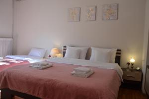 two beds with towels on top of them in a bedroom at Daizy's Apartment in Volos