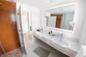 a white bathroom with a sink and a mirror at Private Iberosta Villa Fortuna - 4BDR, Pool & Private Beach in Punta Cana