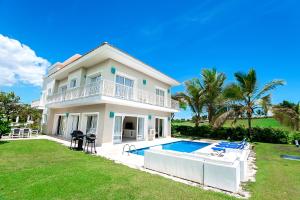 a large house with a swimming pool in the yard at Private Iberosta Villa Fortuna - 4BDR, Pool & Private Beach in Punta Cana
