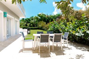 a white table and chairs on a patio at Private Iberosta Villa Fortuna - 4BDR, Pool & Private Beach in Punta Cana +37 photos