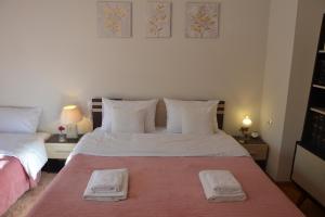 a bedroom with a bed with two towels on it at Daizy's Apartment in Volos