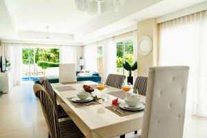 a dining room and living room with a table and chairs at Private Iberosta Villa Fortuna - 4BDR, Pool & Private Beach in Punta Cana