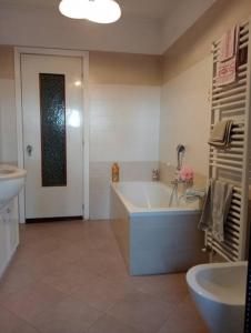 a bathroom with a tub and a toilet and a sink at Casa Il giardino in Ca degli Oppi +19 photos