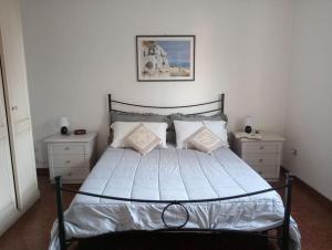 a bedroom with a bed with two dressers and a picture at Casa Il giardino in Ca degli Oppi