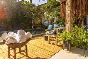 a patio with a pool and a chair and a tub at Awe Villa Boutique Trancoso in Trancoso
