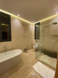 bagno con vasca e doccia in vetro di Villa 7palms a Marrakech