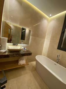 bagno con vasca, lavandino e specchio di Villa 7palms a Marrakech