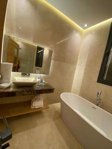 a bathroom with a tub and a sink and a mirror at Villa 7palms in Marrakesh +10 photos