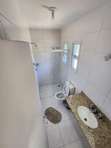Baño blanco con lavabo y aseo en Hospedaria Ilhabela - Casa Maritacas, en Ilhabela