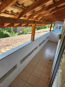 porche con techo de madera y suelo de baldosa en Hospedaria Ilhabela - Casa Maritacas, en Ilhabela
