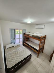 1 dormitorio con 2 literas y ventana en Hospedaria Ilhabela - Casa Maritacas, en Ilhabela