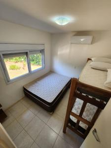 伊利亞貝拉的住宿－Hospedaria Ilhabela - Casa Maritacas，一间小卧室,配有两张床和窗户
