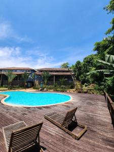 2 sillas y una piscina en una terraza de madera en Hospedaria Ilhabela - Casa Maritacas, en Ilhabela