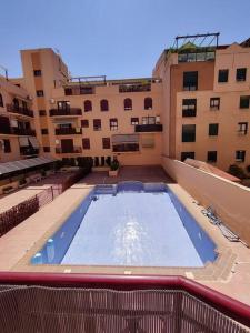 a large swimming pool in the middle of a building at Apartamento, piscina y parking Granada Tico Medina in Granada