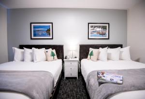 duas camas num quarto de hotel com paredes brancas em Main Street Motel em Bar Harbor