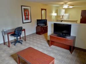 a hotel room with a desk and a chair and a television at Southfield Stay in Southfield